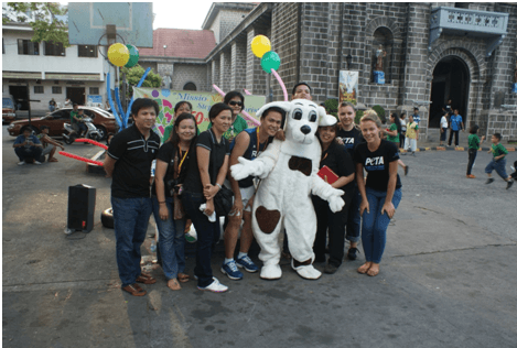 Milena (far right), Spot the “dog,” and others pose at a tabling event in Manila.